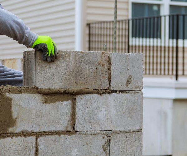 Plaster at construction masonry worker make concrete wall by cement block Plaster at construction masonry worker make concrete wall by cement block